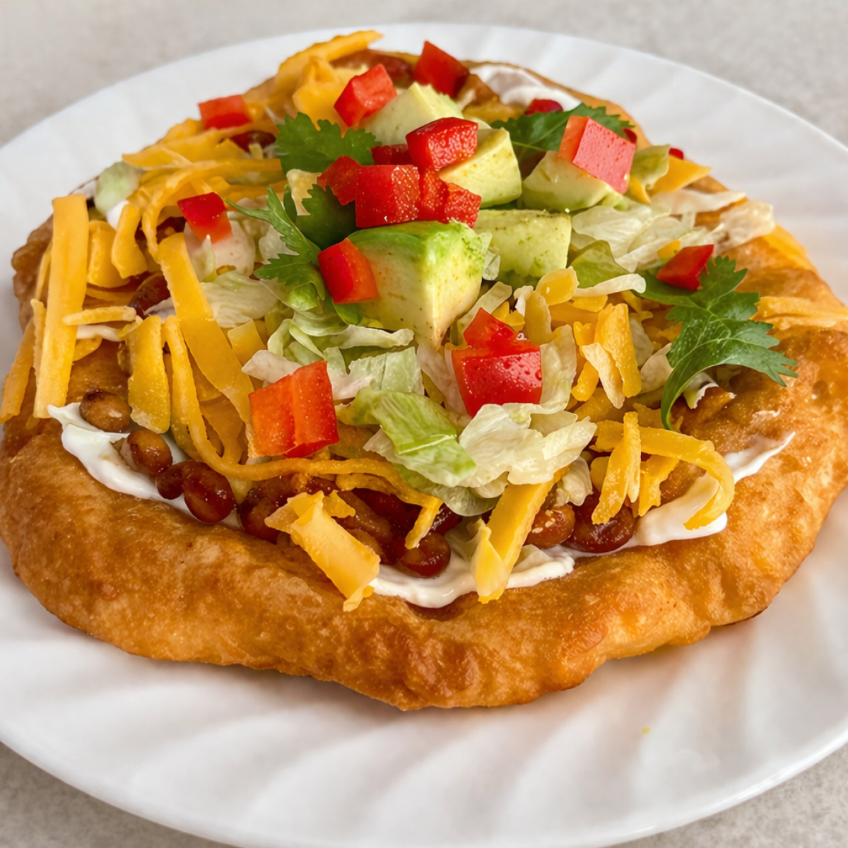 A piece of traditional Indian fry bread, golden brown and fluffy, fried to perfection and loaded with traditional toppings.