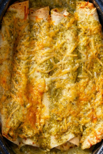 Gluten-free chicken enchiladas baked in green enchilada sauce and melted cheese in a casserole dish.