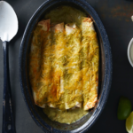 Baked gluten-free chicken, enchiladas, covered in green sauce and melted cheese in a casserole dish