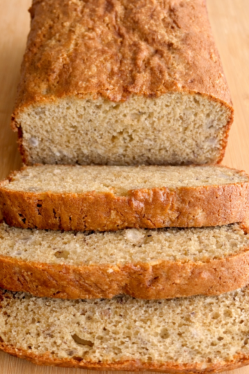 Slices of moist banana bread with a golden-brown crust, served on a white plate with a soft, tender crumb visible.