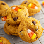 A stack of three super soft pumpkin chocolate chip cookies on a cooling rack.