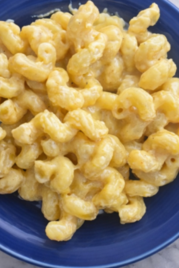 Creamy smoked gouda mac and cheese served on a blue plate with rich, cheesy sauce.