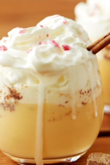 Rich and creamy non-alcoholic eggnog made with a cooked custard base, served chilled in a glass with crushed candy canes on top.