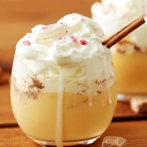 Rich and creamy non-alcoholic eggnog made with a cooked custard base, served chilled in a glass with crushed candy canes on top.