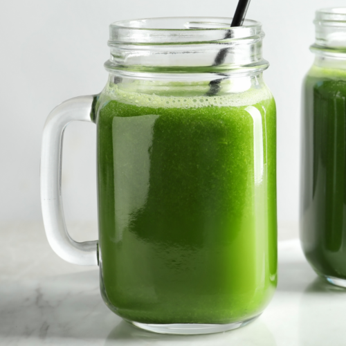 Fresh green detox juice made with cucumber, apple, spinach, mint, and lemon in a glass