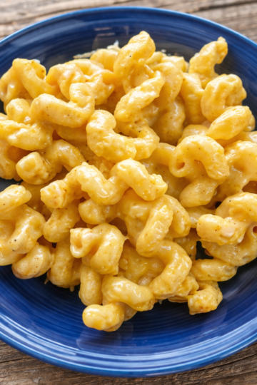 Smoked gouda mac and cheese in a blue bowl on rustic wooden table