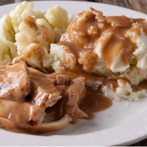Gluten free sourdough discard gravy on mashed potatoes , smooth and creamy with a rich golden-brown color.