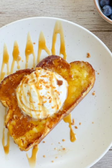 Dreamy coconut cream pie French toast topped with whipped cream and toasted coconut.