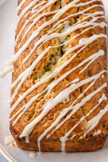 Tropical coconut lime banana bread sliced on a plate, showing a moist crumb with coconut and fresh lime glaze.