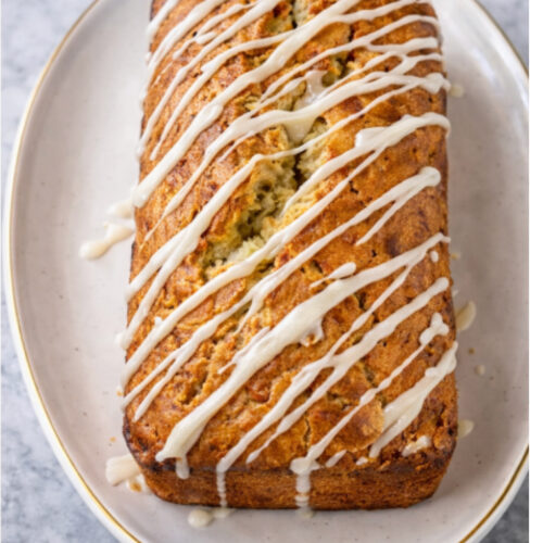 Tropical coconut lime banana bread sliced on a plate, showing a moist crumb with coconut and fresh lime glaze.