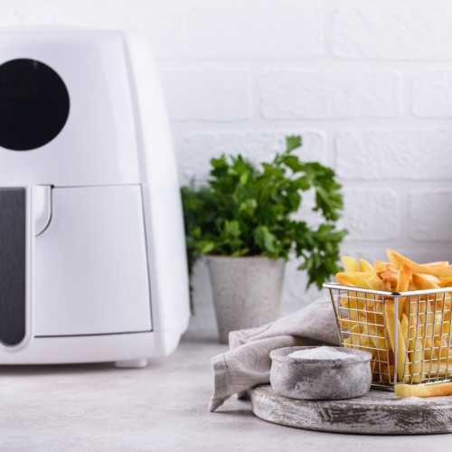 A neatly organized kitchen counter with an air fryer and crispy fries.
