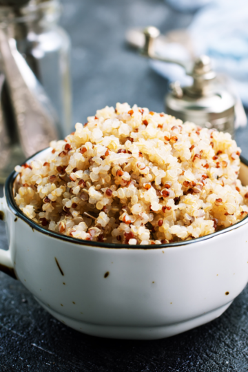 Fluffy cooked quinoa in a white bowl, showing perfectly separated grains and a light, nutty texture.