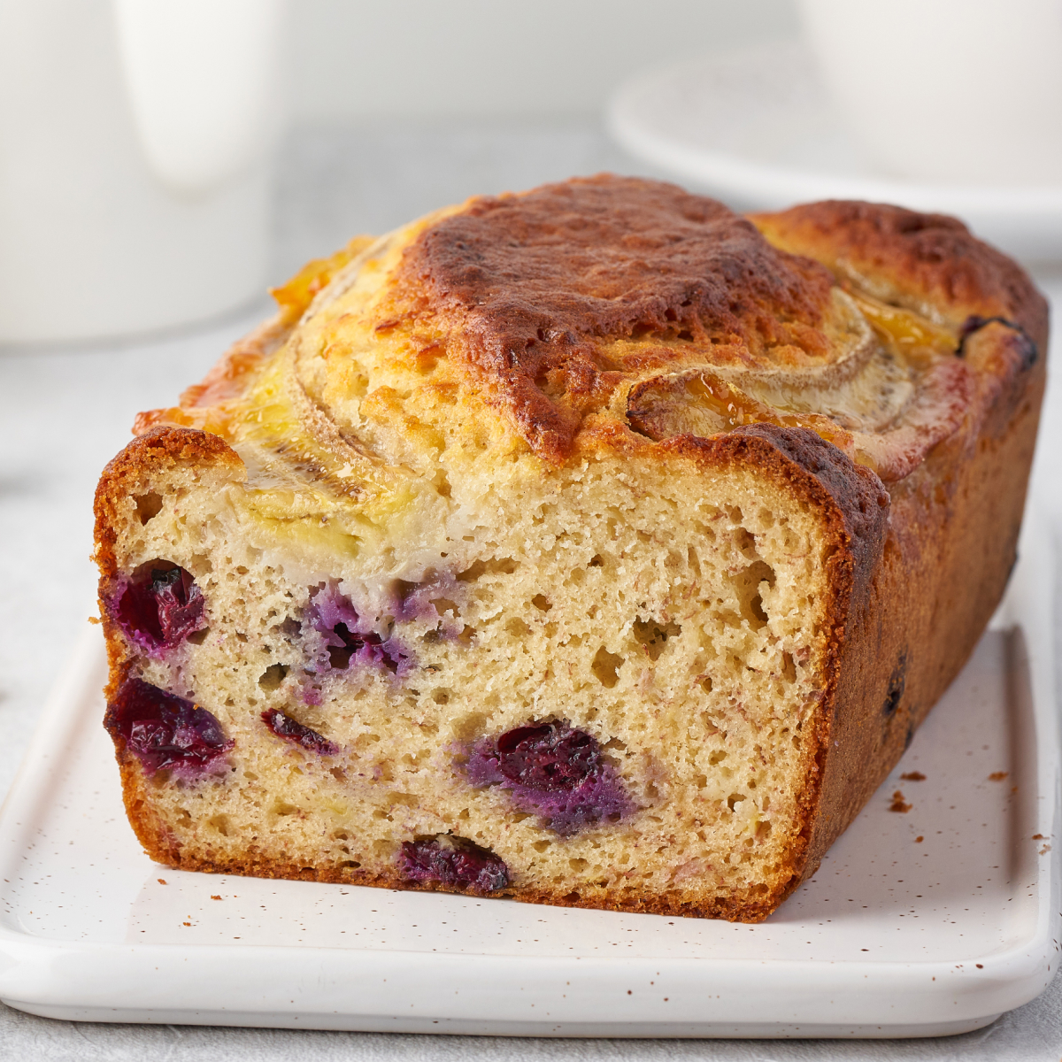 Moist banana bread on a nice white ceramic serving dish.