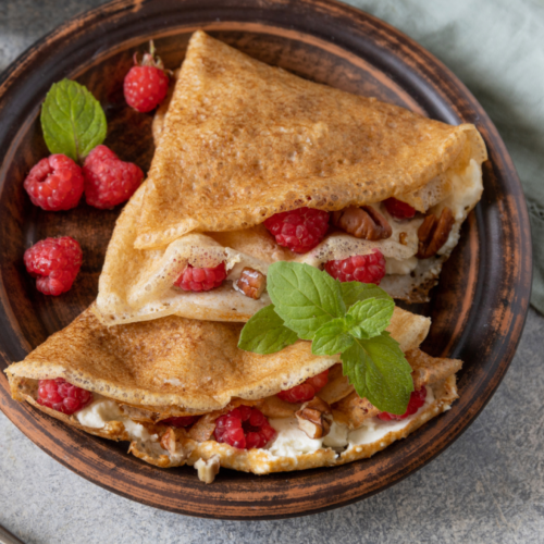 Sourdough crepes filled with fresh colorful fruit and fluffy cream.