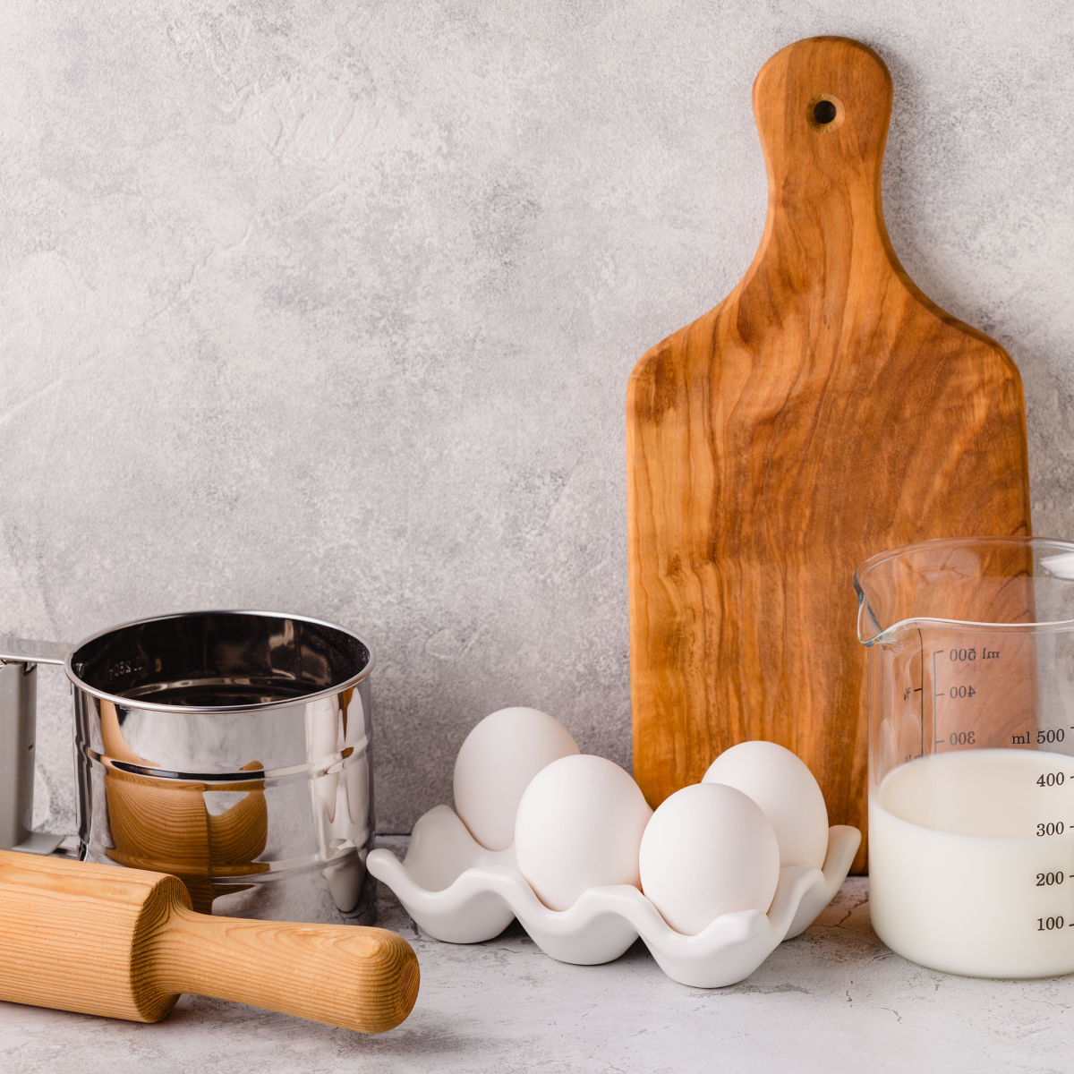 A bright clean countertop filled with kitchen equipment and baking goods.