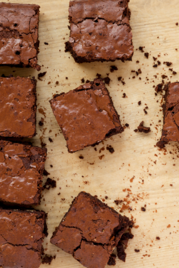 Perfectly cut gooey and chocolatey brownies on counter top.