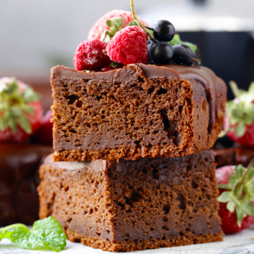 Perfectly cut gooey and chocolatey brownies on a serving plate.