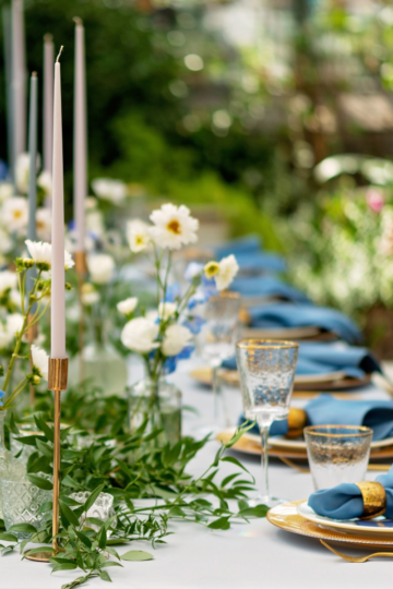 A beautiful table decorated with fresh flowers and candle sticks. Table settings for a party.