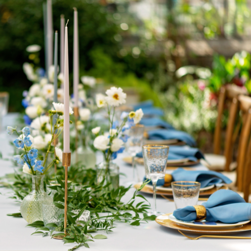 A beautiful table decorated with fresh flowers and candle sticks. Table settings for a party.