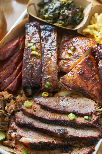 A full spread of barbecue meats; pulled pork, ribs and brisket all served on a tray ready for a crowd.