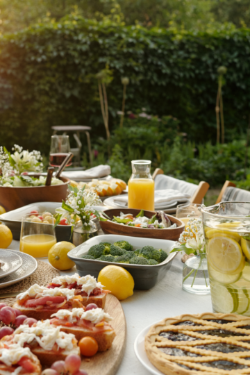 A lovely table set with salad, appetizers, pies, breads and drinks with perfect portions for a large crowd.