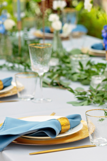 A perfectly set table with glass goblets setting ready for a dinner party.