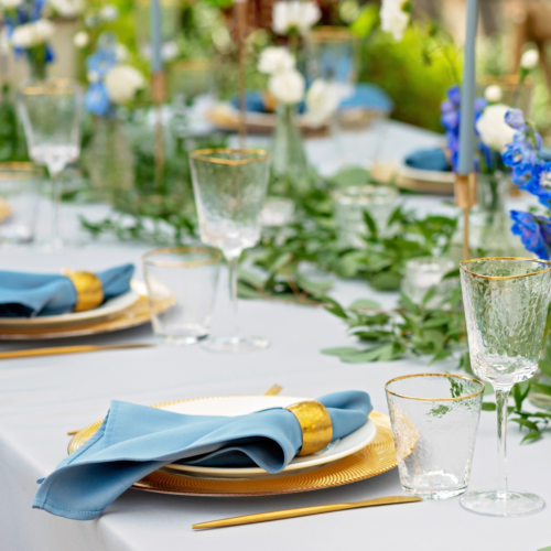 A perfectly set table with glass goblets setting ready for a dinner party.