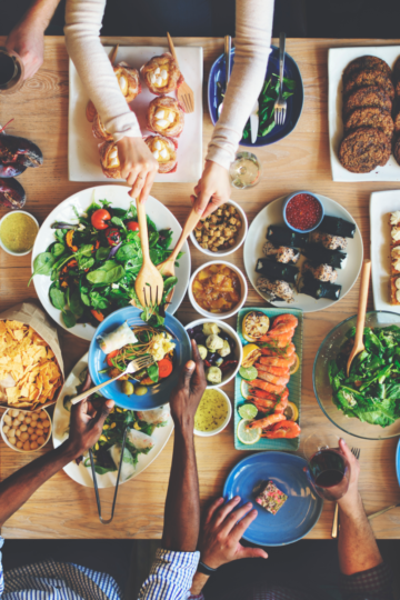 A buffet table filled with a variety of foods ready to serve a large crowd.