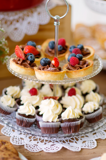 A beautifully decorated table filled with small desserts on a nice serving tray.
