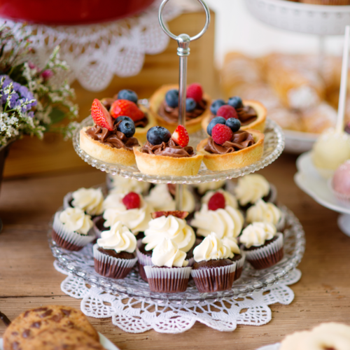 A beautifully decorated table filled with small desserts on a nice serving tray.