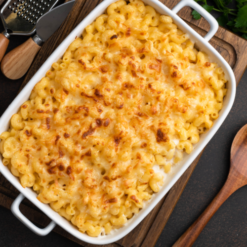 Top-down view of a 9x13 pan of homemade baked mac and cheese with golden bubbly topping.